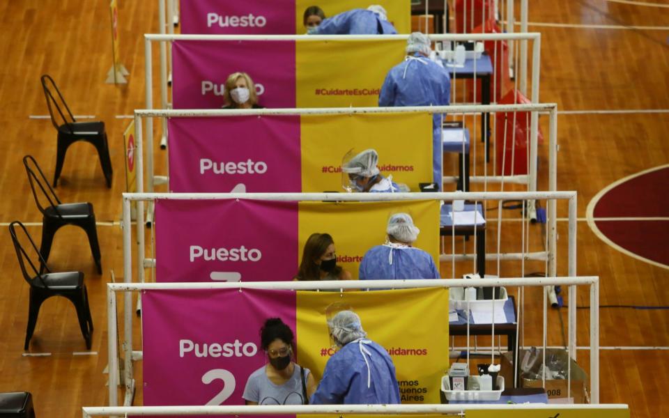 People receive doses of Russia's Sputnik V vaccine against the coronavirus disease (COVID-19) at the basket ball court at the River Plate stadium - Matias Baglietto/Reuters