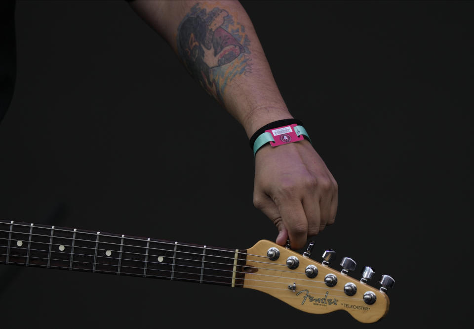 Un integrante de Lost Acapulco afina su guitarra antes de su presentación en el festival Vive Latino en la Ciudad de México el domingo 19 de marzo de 2023. (Foto AP/Fernando Llano)