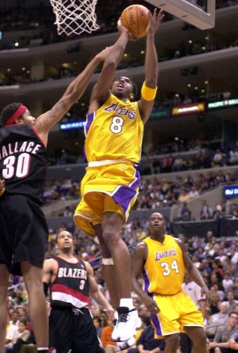 Los Angeles Lakers star Kobe Bryant leaps to score a basket over Portland's Rasheed Wallace, left, and Damon Stoudamire while Lakers teammte Shaquille O'Neal watches during a 2001 Lakers' NBA victory