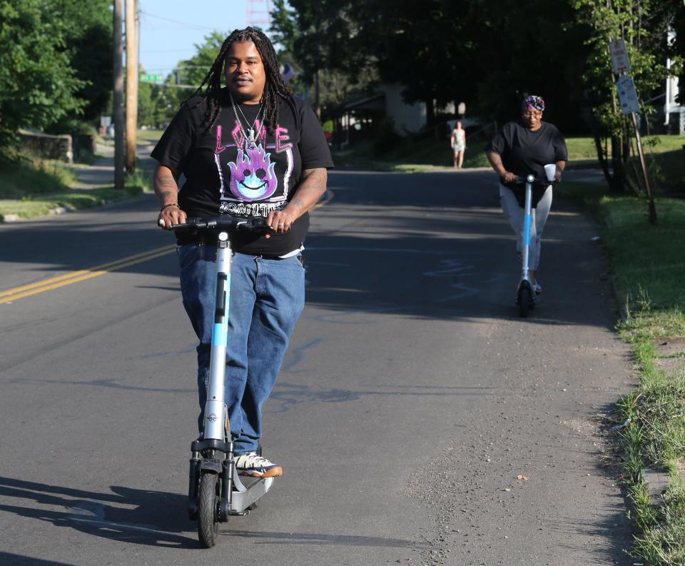 DaShawn Robinson, front, and Shalonda Thompson ride Bird scooters through Canton in late June. The city and company say the scooters have been popular with residents since they were introduced more than two months ago.