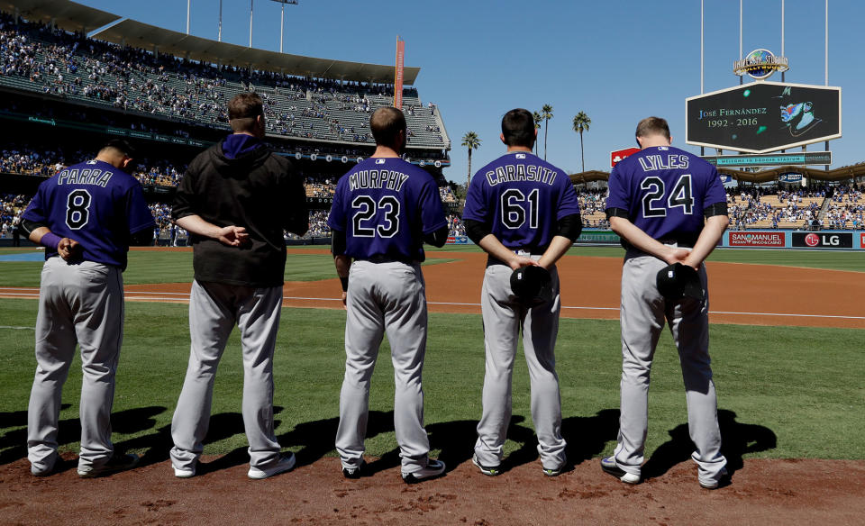 <p>Members of the Colorado Rockies observe a moment of silence in memory of Miami Marlins pitcher Jose Fernandez who died in a boating accident early Sunday, before a baseball game against the Los Angeles Dodgers in Los Angeles, Sunday, Sept. 25, 2016. (AP Photo/Chris Carlson) </p>