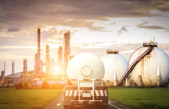 A gas and oil transportation truck in front of a plant.