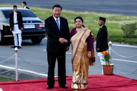 Nepal's President Bidhya Devi Bhandari shakes hands with China's President Xi Jinping during a welcome ceremony at the Tribhuvan International Airport in Kathmandu