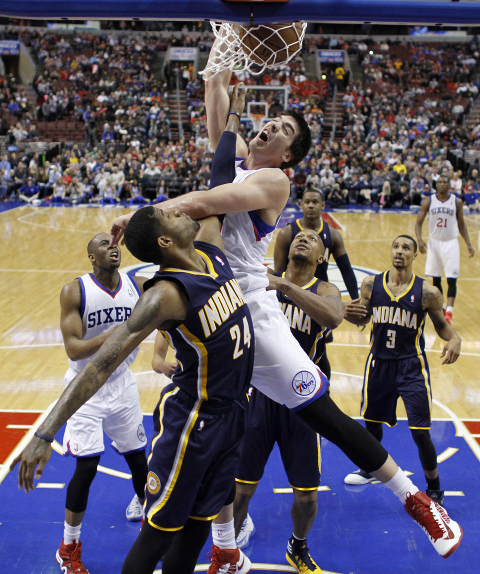 Philadelphia 76ers' Byron Mullens, center, dunks the ball against Indiana Pacers' Paul George during the first half of an NBA basketball game on Friday, March 14, 2014, in Philadelphia. (AP Photo/Matt Slocum)