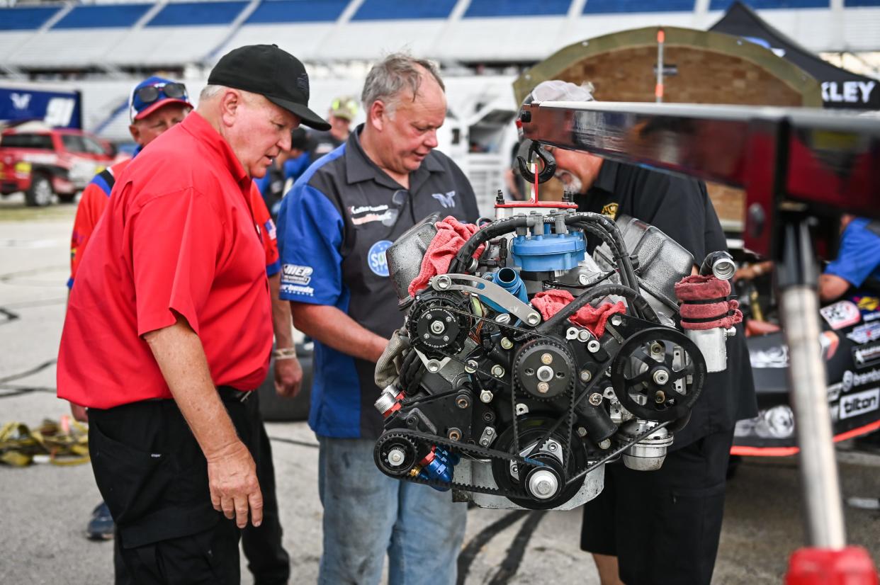 Freddie Query, competition director for the ASA STARS National Tour, left, looks on as the engine is pulled from Ty Majeski's second-place car Sunday after the Father’s Day 100 at the Milwaukee Mile.