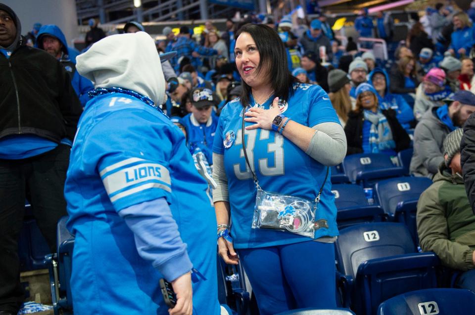 Megan Stefanski chats with a fellow Lions fan next to a tribute to her father Donnie "Yooperman" Stefanski before the start of the game against the L.A. Rams at Ford Field on Sunday, Jan. 14, 2023.