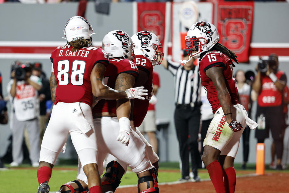 North Carolina State's Keyon Lesane (15) celebrates his touchdown with teammates Timothy McKay (52), Chandler Zavala, center, and Devin Carter (88) during the first half of an NCAA college football game against Wake Forest in Raleigh, N.C., Saturday, Nov. 5, 2022. (AP Photo/Karl B DeBlaker)