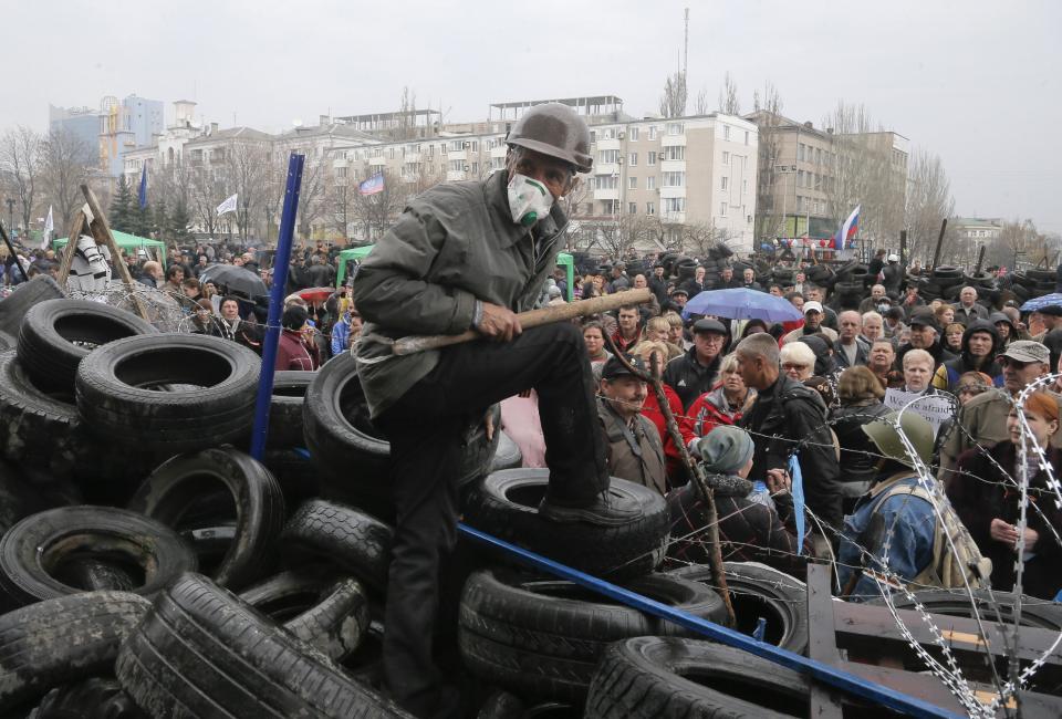 A masked pro-Russian activist guards a barricade during a rally at the regional administration building that they had seized earlier in Donetsk, Ukraine, Thursday, April 10, 2014. in Donetsk, Ukraine, Thursday, April 10, 2014. Ukraine’s acting president on Thursday promised pro-Russian activists occupying government buildings in the country’s east that they will not be prosecuted if they lay down their arms, as protests continue to flare up across Ukraine’s industrial heartland. (AP Photo/Efrem Lukatsky)