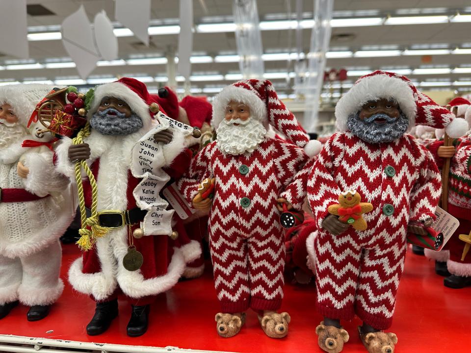 Display of Santa Clauses with different skin tones wearing a range of outfits from furry coats to chevron pajamas on a shelf