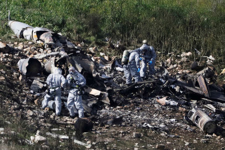 Israeli security forces examine the remains of an F-16 Israeli war plane near the village of Harduf, Israel February 10, 2018. REUTERS/ Ronen Zvulun