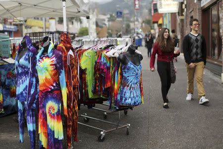 People pass a rack of tie-dyed clothing for sale along Telegraph Avenue in Berkeley, December 9, 2014. REUTERS/Robert Galbraith