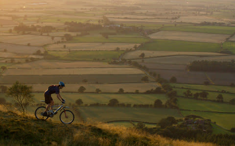  Mountain biker riding down a hill - Credit: Cultura RF