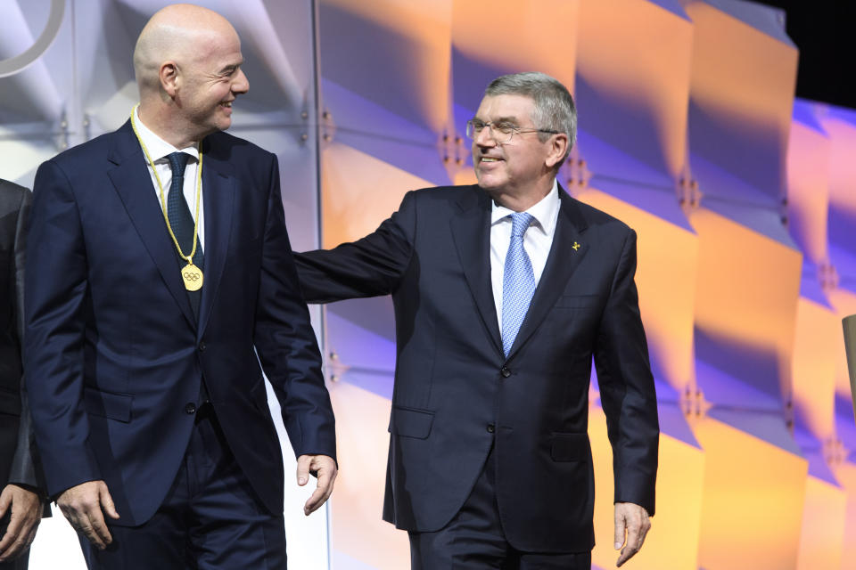 FILE - FIFA President Gianni Infantino, left, speaks with IOC president Thomas Bach after he was elected as IOC member during the 135th Session of the International Olympic Committee on the sideline of the the 3rd Winter Youth Olympic Games Lausanne 2020, in Lausanne, on Jan. 10, 2020. The Olympics and international soccer once lived through very public corruption crises. The International Olympic Committee had the Salt Lake City bidding scandal. Soccer faced waves of bribery allegations in 2015 that removed the FIFA and UEFA presidents. In crisis they agreed to limit presidents to 12 years in office to help curb power cliques. This rule now faces pushback. (Laurent Gillieron/Keystone via AP, File)