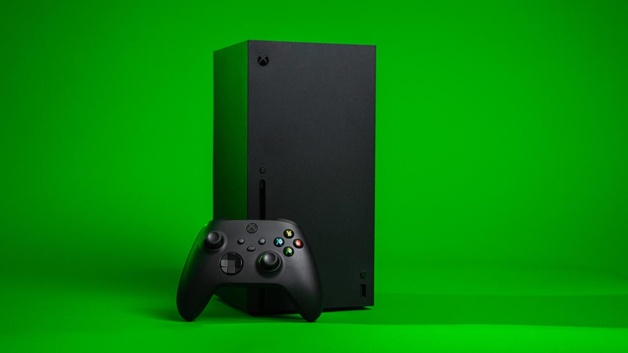  A back Xbox and Xbox controller against a bright green background. 