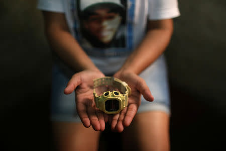 Janaina Mattos Alves shows a watch that belonged to her son Jonatha Dalber at her home in the Borel slum in Rio de Janeiro, Brazil, April 22, 2018. Mattos said her son was was shot dead by the police in 2016 when he was 16-years-old. REUTERS/Pilar Olivares