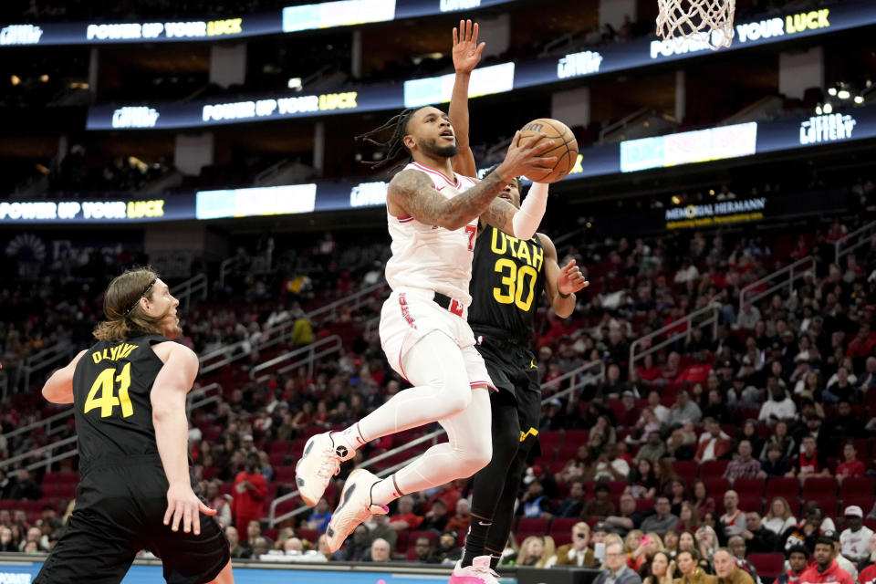 Houston Rockets forward Cam Whitmore, center left, drives to the basket as Utah Jazz guard Ochai Agbaji (30) defends during the first half of an NBA basketball game Saturday, Jan. 20, 2024, in Houston. (AP Photo/Eric Christian Smith)