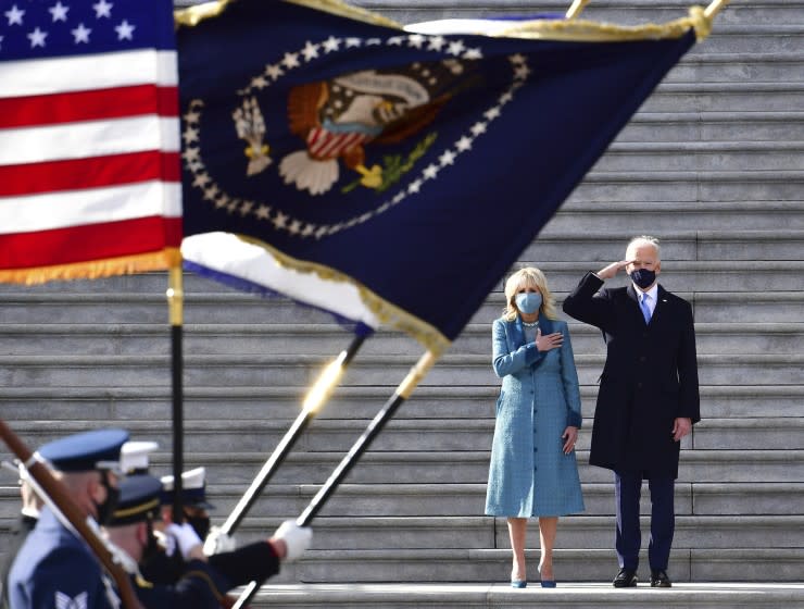 President Joe Biden salutes as his wife Jill puts her hand over her heart as they review the troops from the steps of the U.S. Capitol during the inauguration, Wednesday, Jan. 20, 2021, in Washington. (David Tulis/Pool Photo via AP)