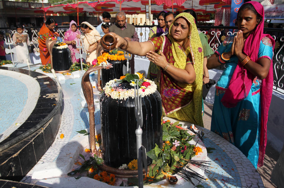 Devotees pour milk on a Shivling, an idol symbolic of Hindu god Shiva, at a temple during "Shivaratri" festival in Ahmadabad, India, Tuesday, Feb. 17, 2015.