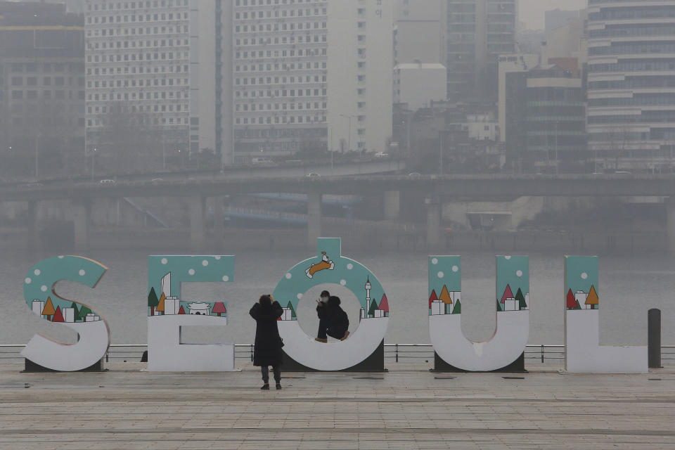 A woman wearing a face mask to help protect against the spread of the coronavirus poses for pictures at a park in Seoul, South Korea, Tuesday, Jan. 26, 2021. (AP Photo/Ahn Young-joon)