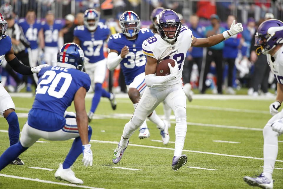 Minnesota Vikings wide receiver Justin Jefferson (18) runs from New York Giants safety Julian Love (20) after catching a pass during the second half of an NFL football game, Saturday, Dec. 24, 2022, in Minneapolis. (AP Photo/Bruce Kluckhohn)