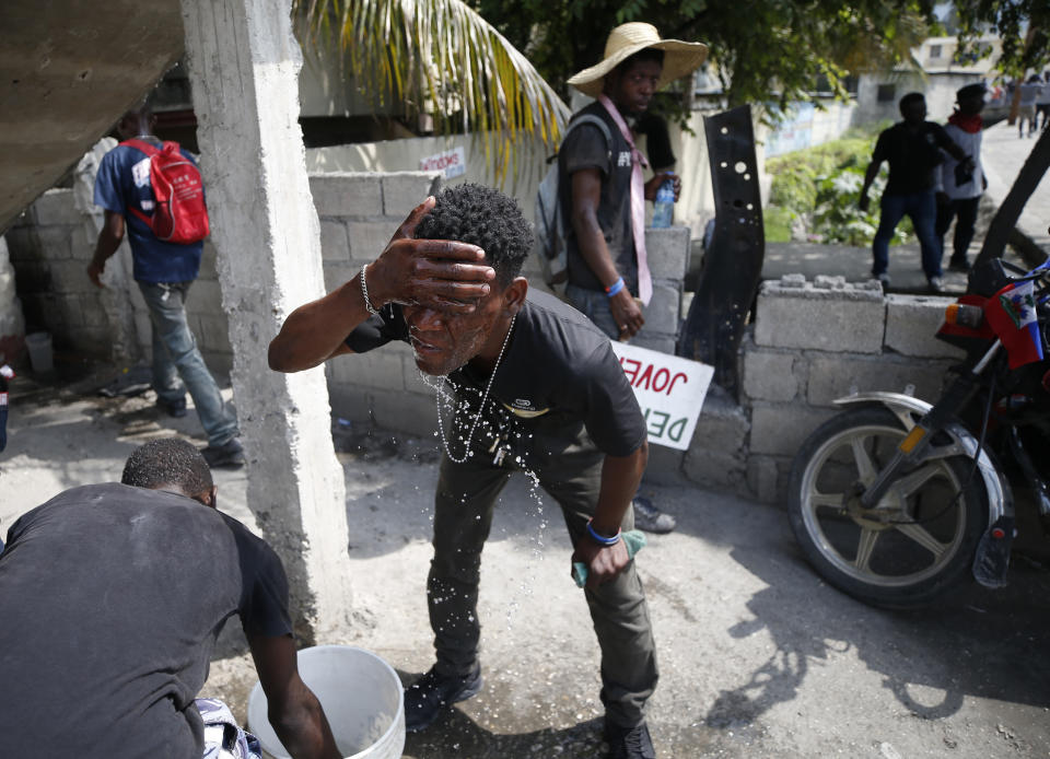 A demonstrator washes his faces from the effects of tear gas during a protest demanding the resignation of President Jovenel Moise, in Port-au-Prince, Haiti, Friday, Oct. 4, 2019. After a two-day respite from the recent protests that have wracked Haiti's capital, opposition leaders urged citizens angry over corruption, gas shortages, and inflation to join them for a massive protest march to the local headquarters of the United Nations. (AP Photo/Rebecca Blackwell)