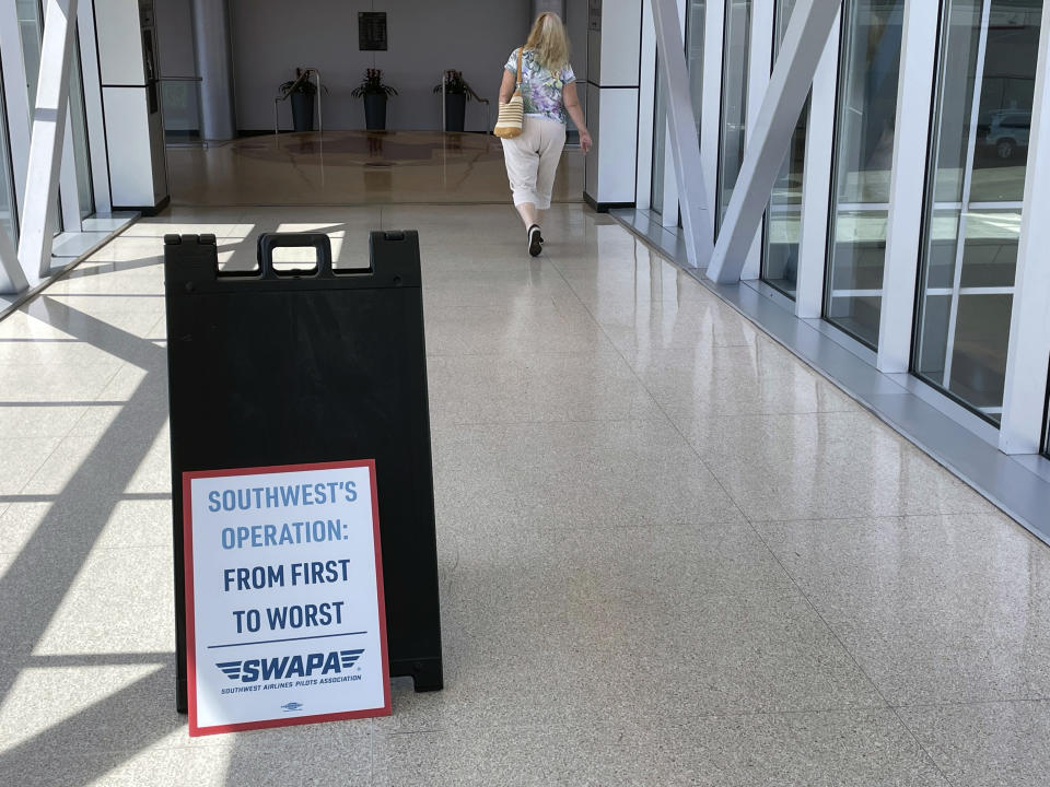 A sign left by a Southwest Airlines pilot is seen in a walkway between parking garages and the terminal at Dallas Love Field, Tuesday, June 21, 2022, in Dallas. (AP Photo/David Koenig)