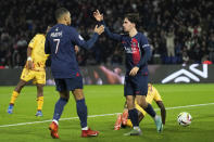 PSG's Vitinha, right, celebrates with teammate Kylian Mbappe after scoring his side's first goal during the French League One soccer match between Paris Saint-Germain and Metz at the Parc des Princes in Paris, Wednesday, Dec 20, 2023. (AP Photo/Michel Euler)