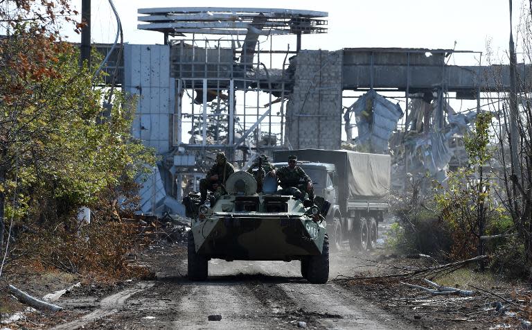 Pro-Russian armoured vehicles drive down the road leading to the remains of Lugansk International Airport, eastern Ukraine, on September 11, 2014