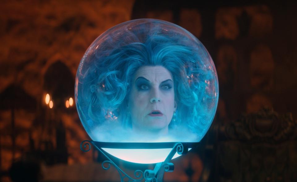 Jamie Lee Curtis as Madame Leota in a crystal ball, with ethereal blue hair and an eerie background in a scene from "Haunted Mansion"