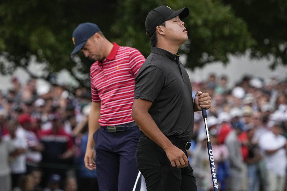 Si Woo Kim, of South Korea, celebrates winning the match against Justin Thomas, right, on the 18th green during their singles match at the Presidents Cup golf tournament at the Quail Hollow Club, Sunday, Sept. 25, 2022, in Charlotte, N.C. (AP Photo/Chris Carlson)