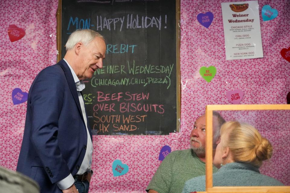 Former Arkansas Gov. Asa Hutchinson speaks Lonnie Shannon, center, and Kathy Shannon on Monday, Jan. 15, 2024, at Waveland Cafe in Des Moines.