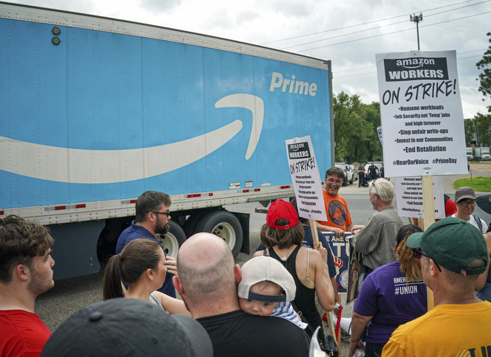 Workers, supporters and activists picket outside the Amazon fulfillment Center in Shakopee, Minn. on the afternoon of Prime Day, Monday, July 15, 2019. Trucks were allowed through the picket line after a brief delay. (Glen Stubbe/Star Tribune via AP)