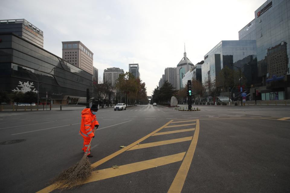 A sanitation worker sweeping a deserted road in Xi'an