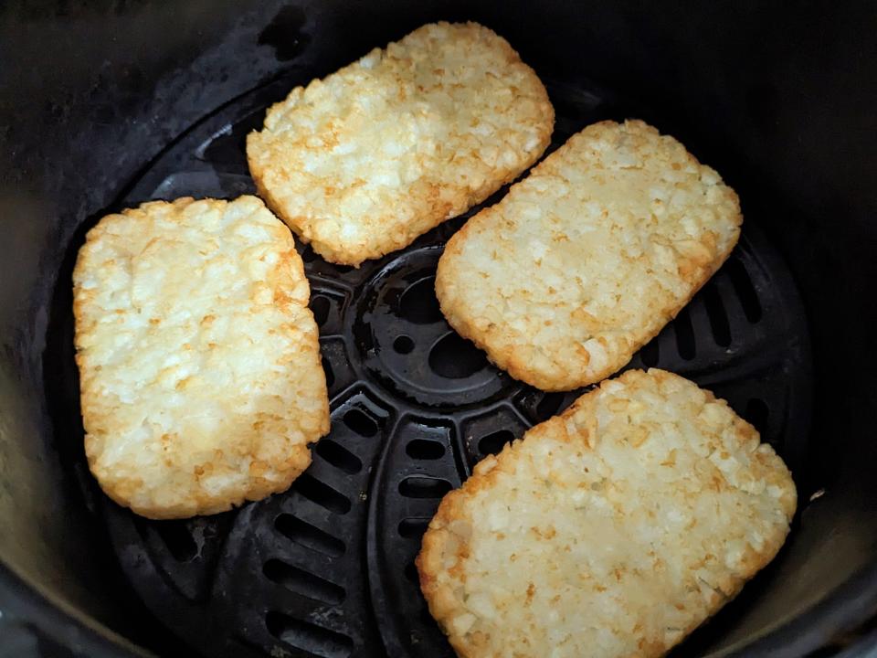 four frozen hash brown in an air fryer basket