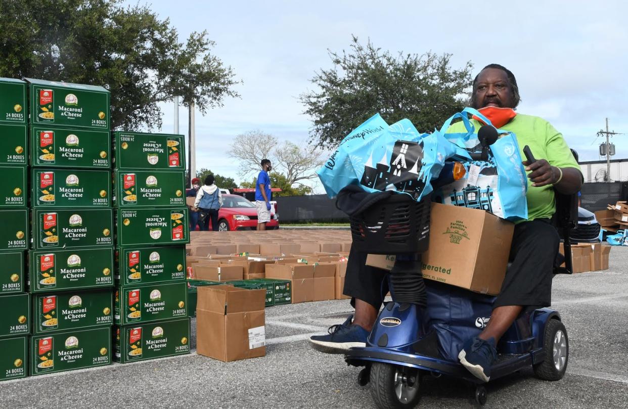 <span class="caption">Stocking up on food can be tough when using a wheelchair, motorized scooter, walker or cane. </span> <span class="attribution"><a class="link " href="https://www.gettyimages.com/detail/news-photo/man-on-a-motorized-wheelchair-carries-food-donated-by-the-news-photo/1229705266" rel="nofollow noopener" target="_blank" data-ylk="slk:Paul Hennessy/NurPhoto via Getty Images;elm:context_link;itc:0;sec:content-canvas">Paul Hennessy/NurPhoto via Getty Images</a></span>