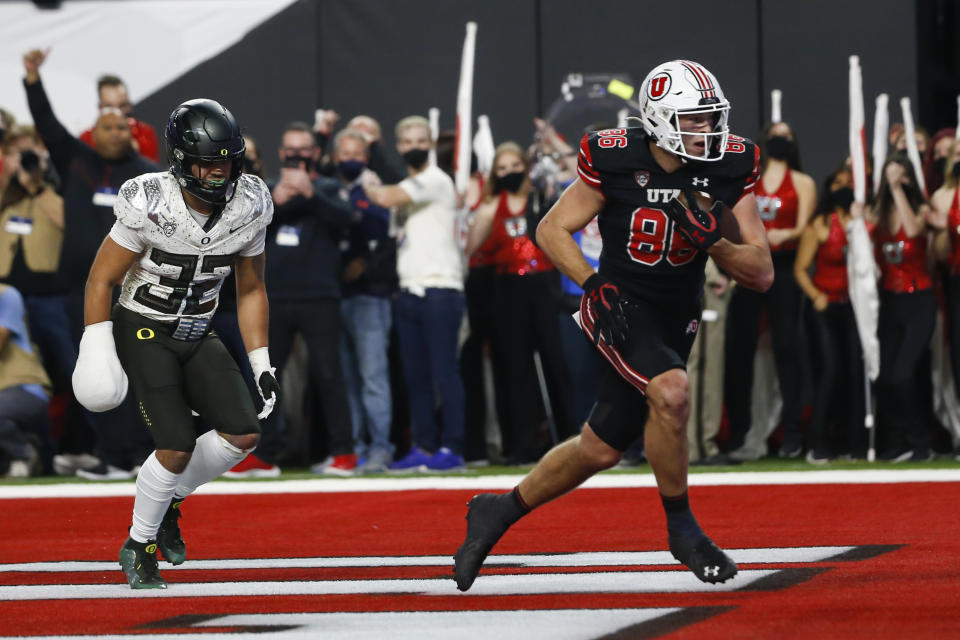 Utah tight end Dalton Kincaid (86) scores a touchdown past Oregon safety Jordan Happle (32) during the first half of the Pac-12 Conference championship NCAA college football game Friday, Dec. 3, 2021, in Las Vegas. (AP Photo/Chase Stevens)