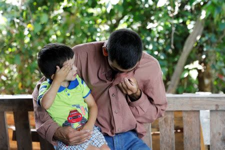 Jose Guardado, 42, a deportee from the U.S. and separated from his son Nixon Guardado, 12 at the McAllen entry point as a result of the Trump administration's hardline immigration policy, gestures with his other son Neimar, 3, as he arrives at his home in Eden, Lepaera, Honduras June 23, 2018. REUTERS/Carlos Jasso