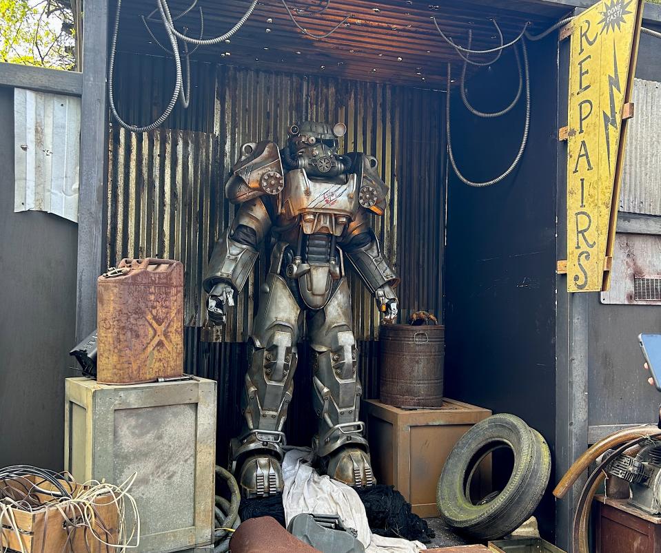 A junkyard featuring a large humanoid robot inspired by "Fallout"