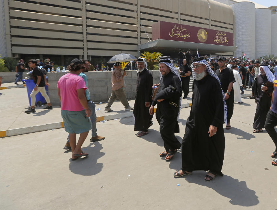 Followers of Shiite cleric Moqtada al-Sadr gather outside the parliament building during a sit-in protest, in Baghdad, Iraq, Monday, Aug. 1, 2022. The political rivals of al-Sadr whose followers stormed the parliament have declared their own counter-protest. The announcement on Monday stirred fear among Iraqis and caused security forces to erect concrete barriers leading to the heavily fortified Green Zone, home of the parliament building. (AP Photo/Anmar Khalil)