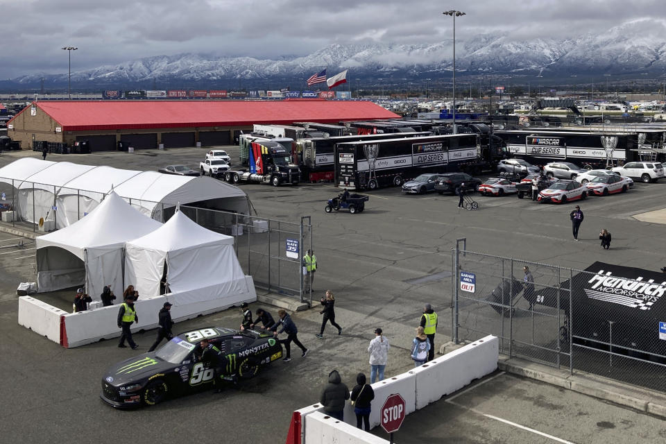 Driver Riley Herbst's crew wheels his NASCAR Xfinity Series car toward the track in Fontana, Calif., Saturday, Feb. 25, 2023. NASCAR has canceled practice and qualifying sessions for the weekend races at Fontana because of ongoing heavy rains. (AP Photo/Greg Beacham)