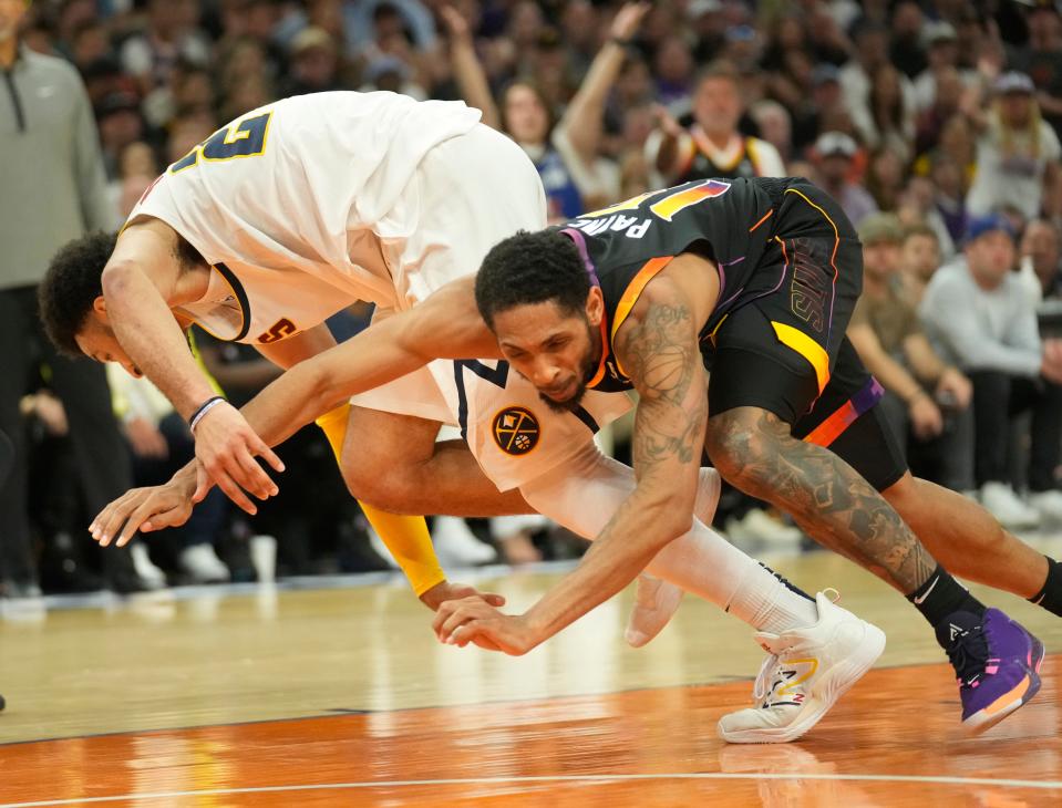 Phoenix Suns guard Cameron Payne (15) gets tangled up with Denver Nuggets guard Jamal Murray (27) during the fourth quarter of Game 4 of the Western Conference Semifinals at Footprint Center on May 7, 2023.