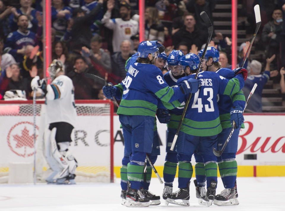 Vancouver Canucks defenseman Quinn Hughes (43) celebrates his goal past San Jose Sharks goaltender Aaron Dell (30) with his teammates during the third period of an NHL hockey game in Vancouver, British Columbia, Saturday, Jan. 18, 2020. (Jonathan Hayward/The Canadian Press via AP)