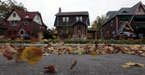 Fall leaves blow past an empty home (C) seen in a well kept neighborhood where the house is listed on the auction block during the Wayne County tax foreclosures auction of almost 9,000 properties in Detroit, Michigan, October 22, 2009. The tax foreclosure auction stood as one of the most ambitious one-stop attempts to sell of urban property since the real-estate market collapse. REUTERS/Rebecca Cook