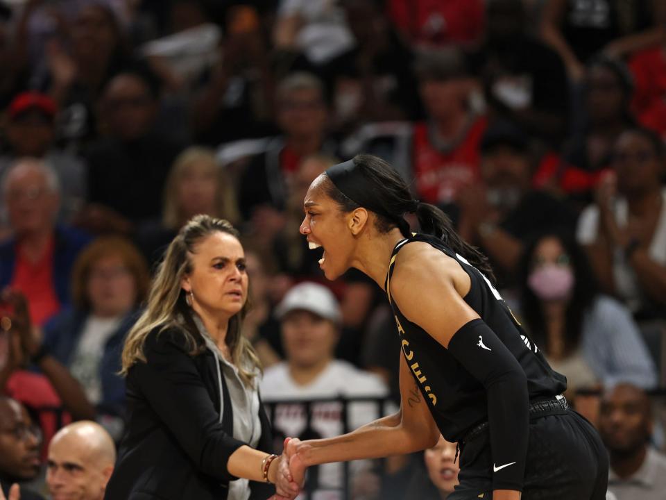 Becky Hammon high-fives A'ja Wilson.