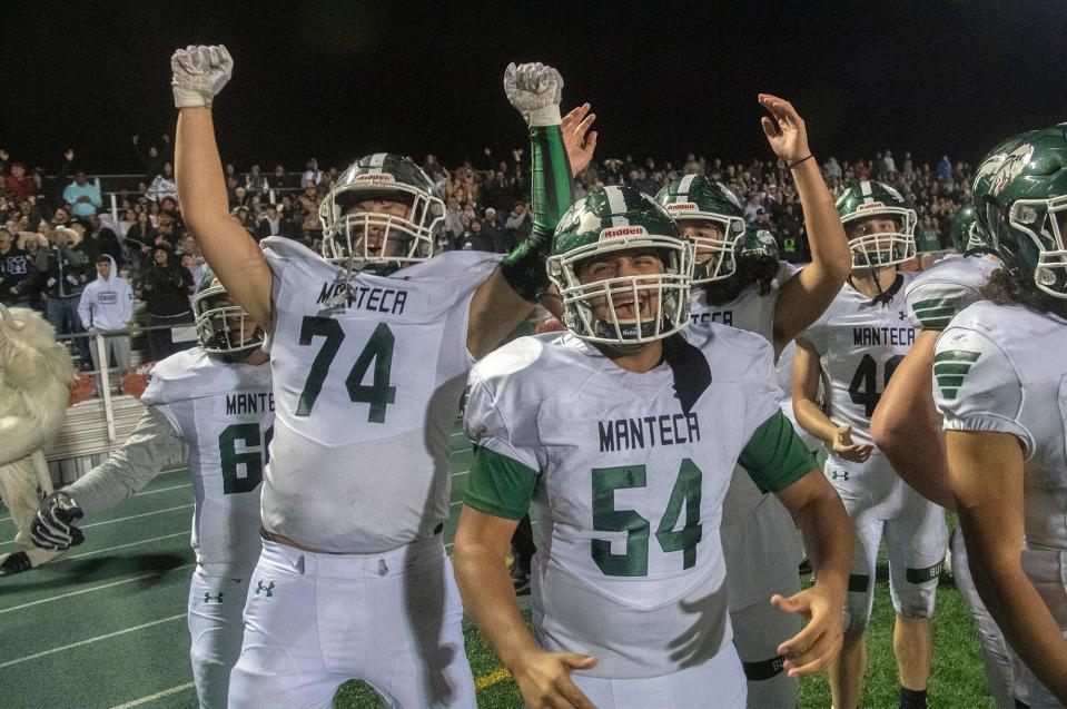 The Manteca bench celebrates the game-winning touchdown during the Sac-Joaquin Section Division III championship game against Oakdale at St. Mary's High School in Stockton. Manteca won 35-28.