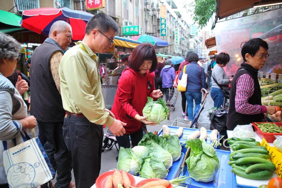 李傳德（左）和魏秀鳳（右）放假日會一起攜手逛菜市場，補齊一禮拜的蔬果量。