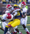 Michigan running back Hassan Haskins (25) is tackled by Rutgers defensive back Christian Izien (0), linebacker Drew Singleton (11), and linebacker Tyshon Fogg (8) in the fourth quarter of an NCAA college football game in Ann Arbor, Mich., Saturday, Sept. 25, 2021. Michigan won 20-13. (AP Photo/Tony Ding)