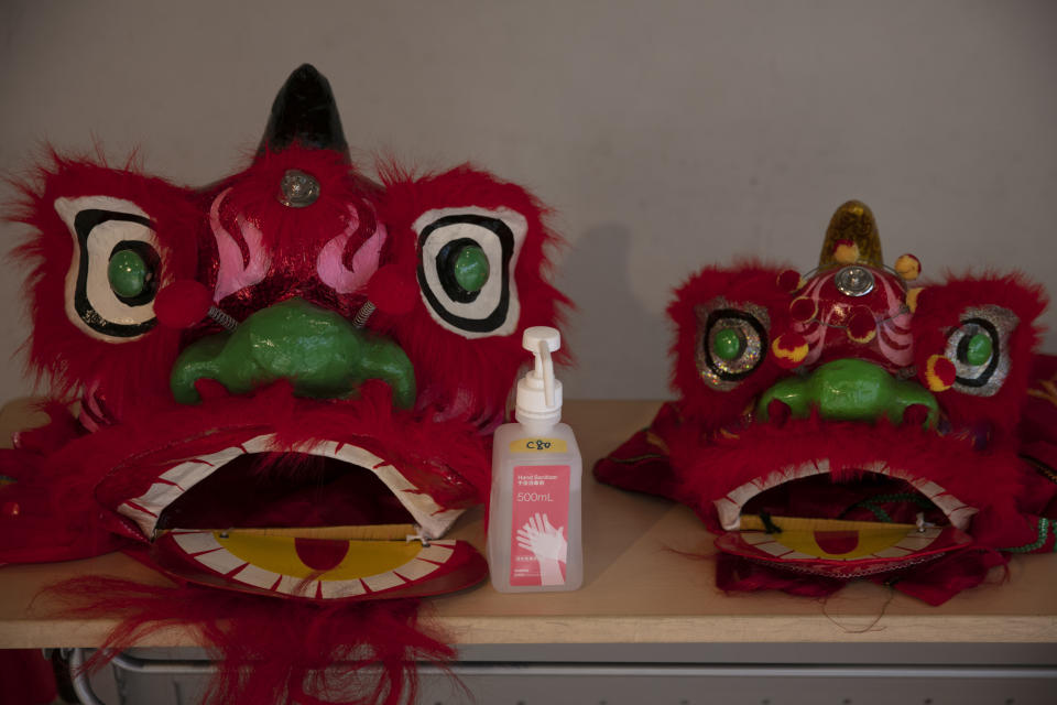 In this Feb. 13, 2020, photo, a bottle of hand sanitizer is placed next to lion masks at an information center in Yokohama's Chinatown, near Tokyo. A top Olympic official made clear Friday the 2020 Games in Tokyo will not be cancelled despite the virus that has spread from China. (AP Photo/Jae C. Hong)