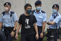 A protester is surrounded by police officers at a street during a protest against an election committee that will vote for the city's leader in Hong Kong Sunday, Sept. 19, 2021. Hong Kong's polls for an election committee that will vote for the city's leader kicked off Sunday amid heavy police presence, with chief executive Carrie Lam saying that it is "very meaningful" as it is the first election to take place following electoral reforms. (AP Photo/Vincent Yu)