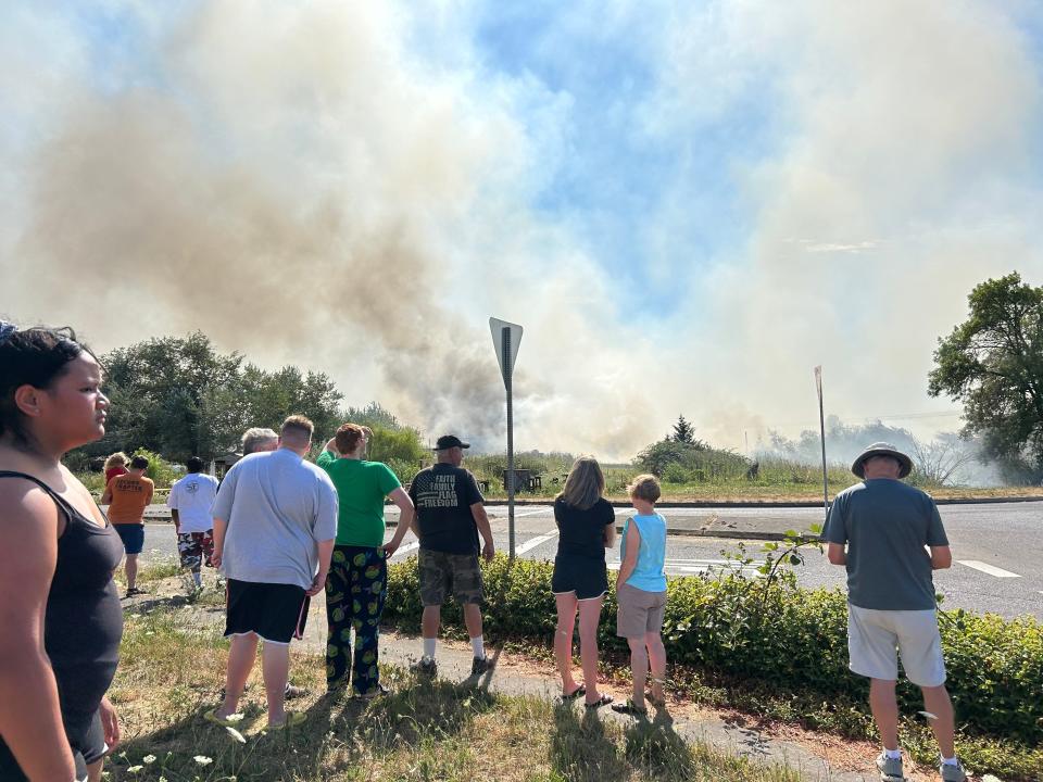 A crowd gathers near the site of a fire reported fire south of the Eugene airport Monday afternoon.